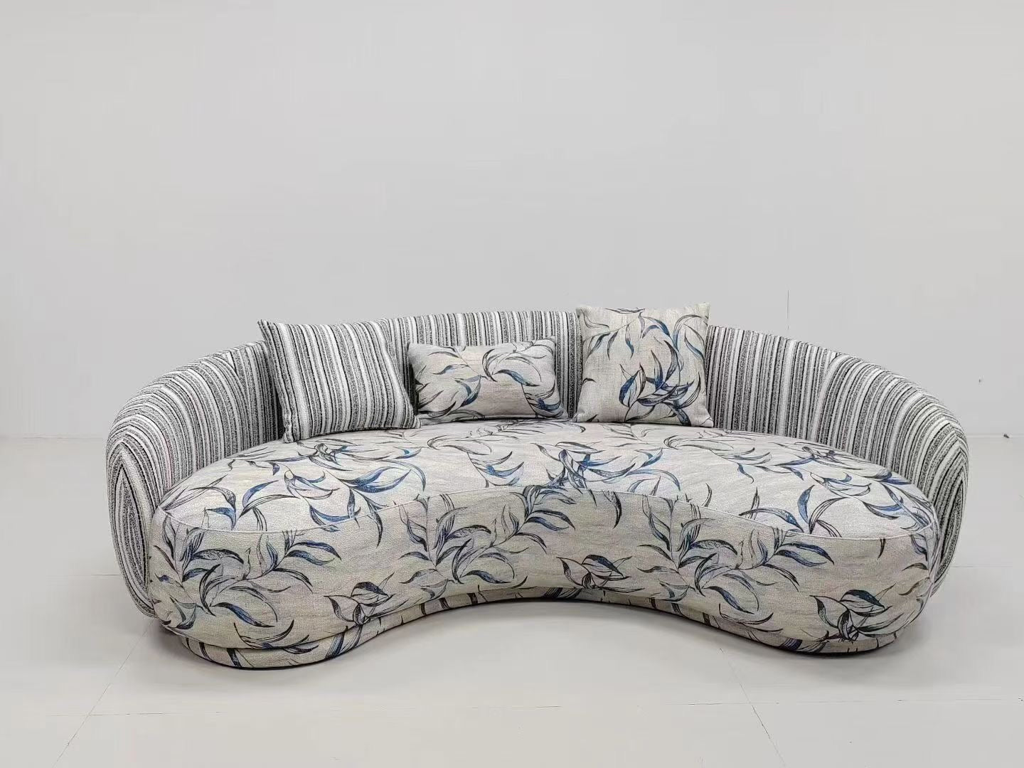 Canapé d'angle courbe en tissu jacquard motif feuillage et dossier rayé