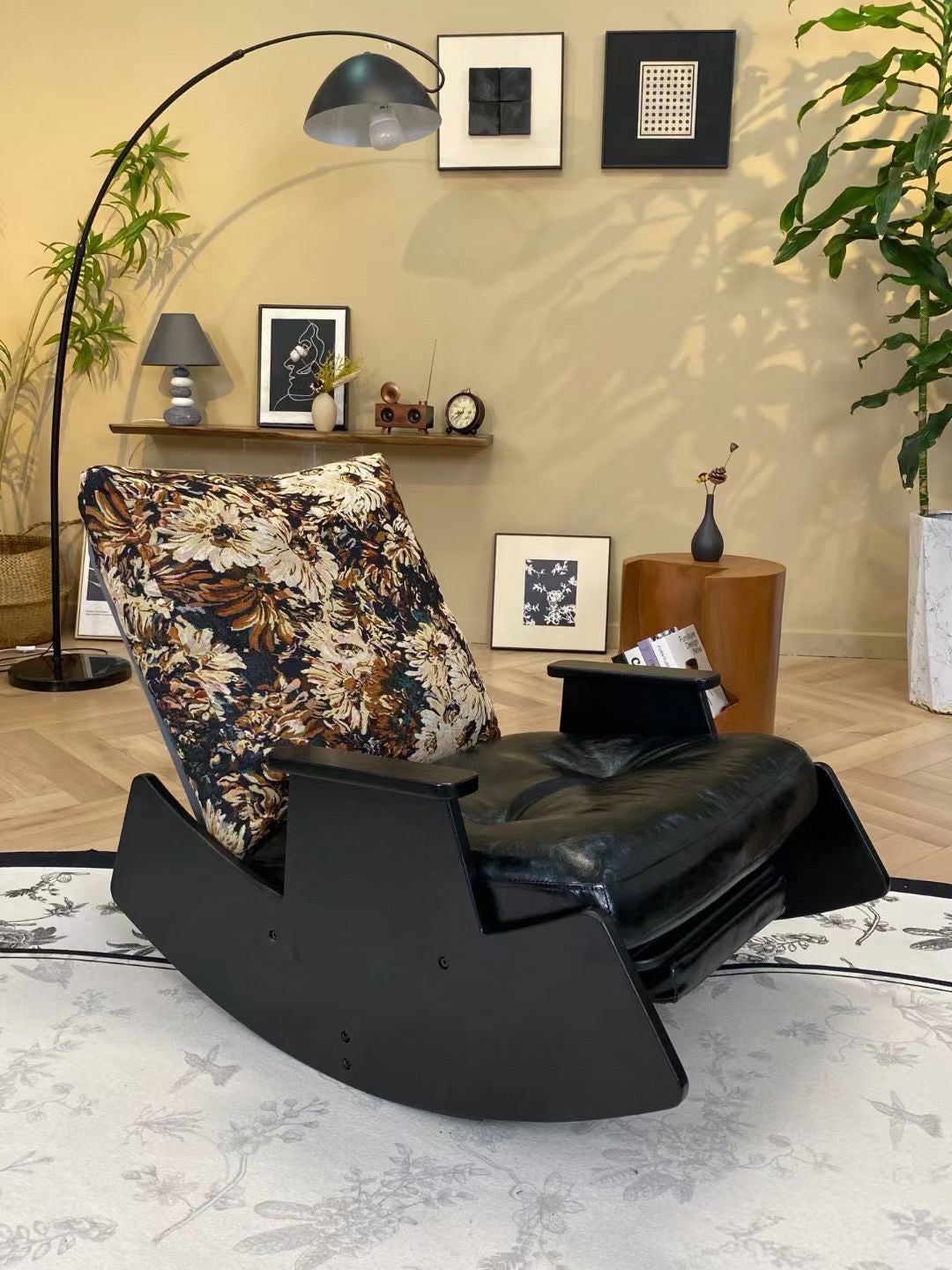Fauteuil à bascule en bois laqué noir, cuir patiné et coussin jacquard floral