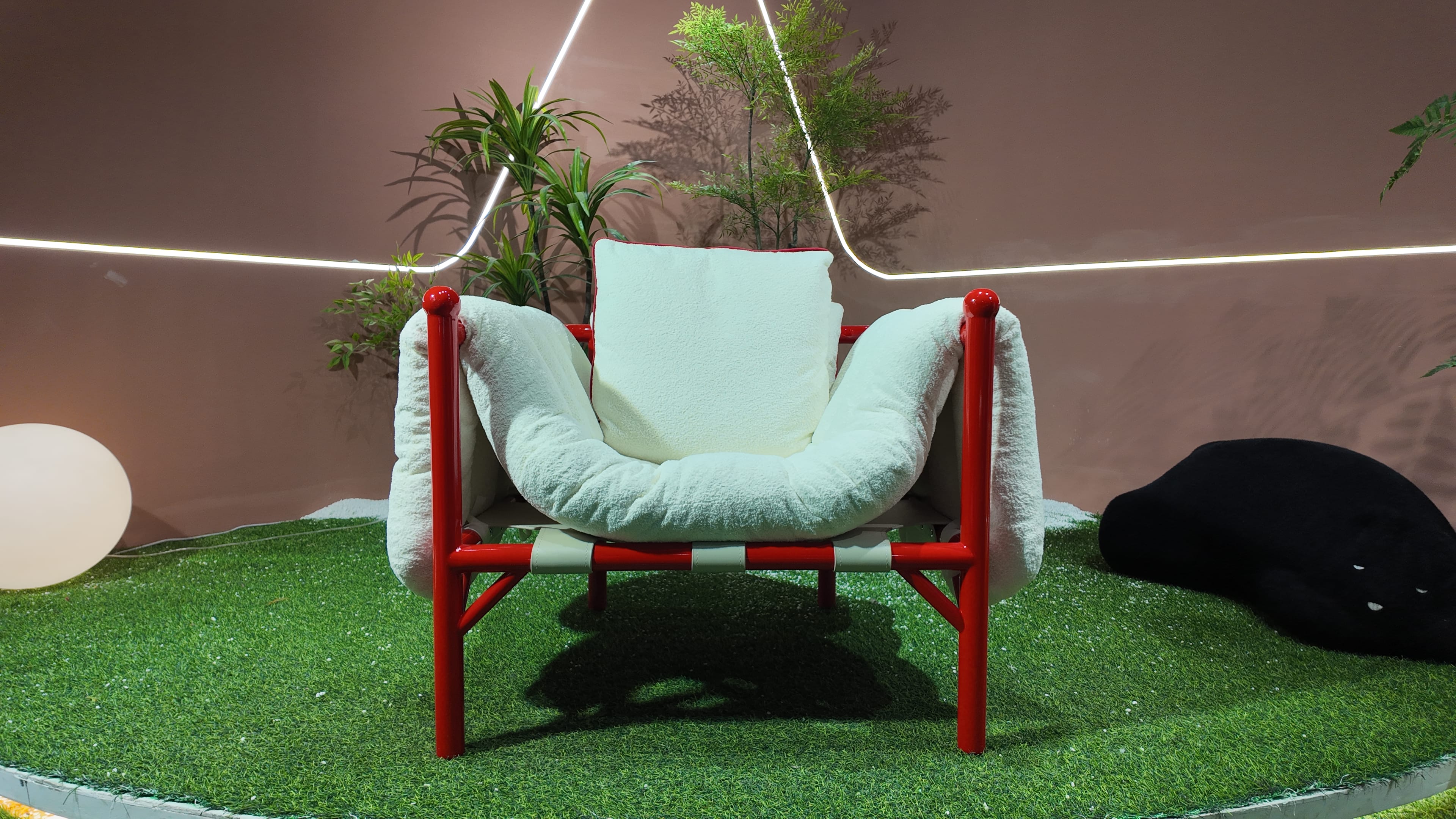 Fauteuil design en tissu bouclé et structure tubulaire laquée rouge – Détente