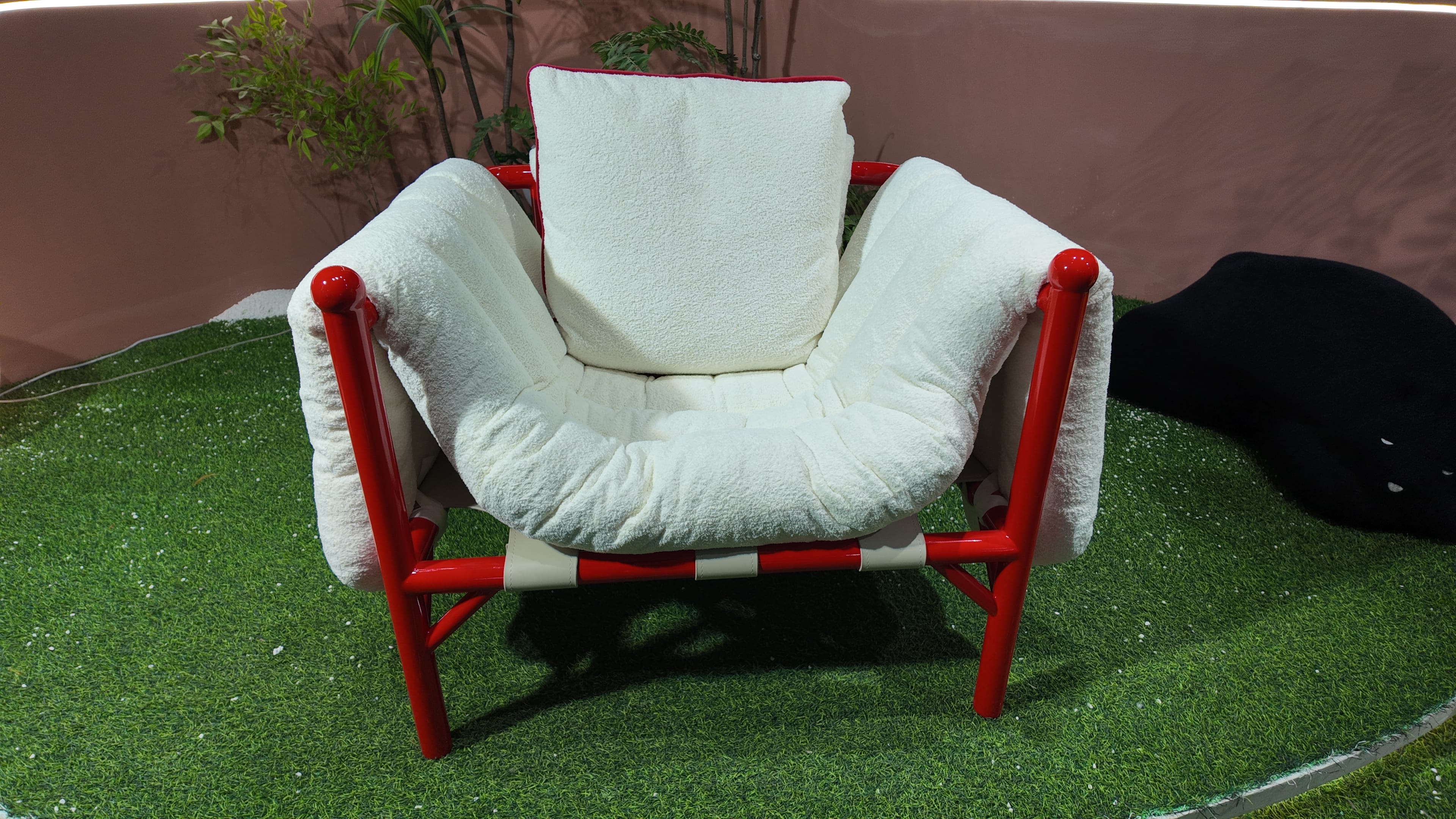 Fauteuil design en tissu bouclé et structure tubulaire laquée rouge – Détente