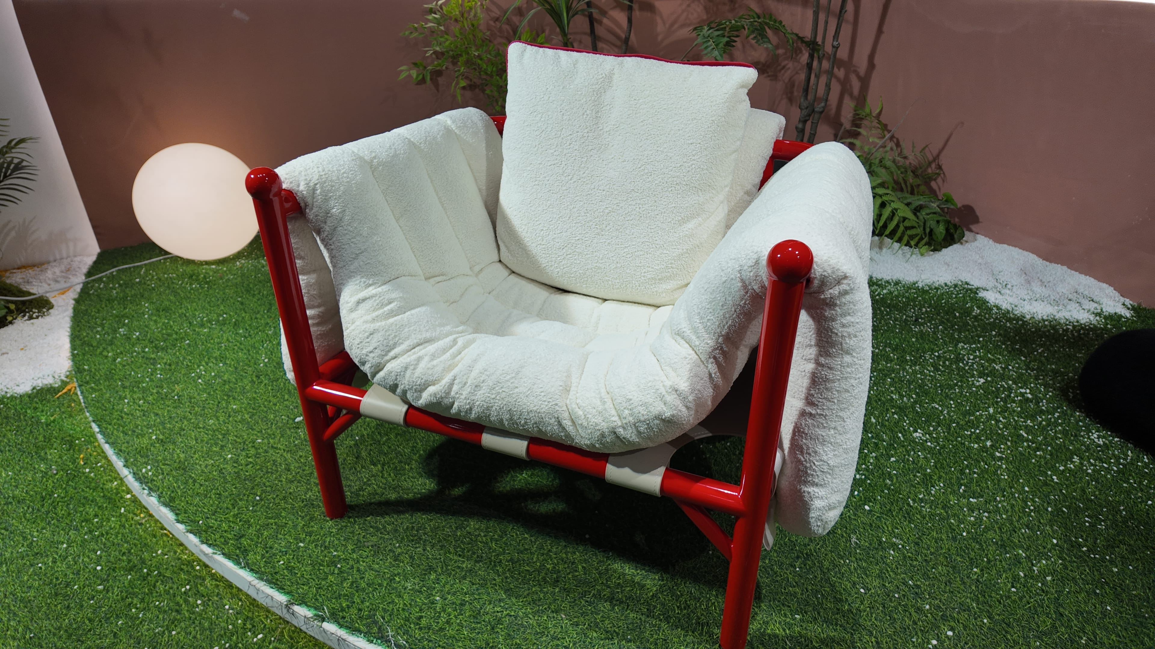 Fauteuil design en tissu bouclé et structure tubulaire laquée rouge – Détente