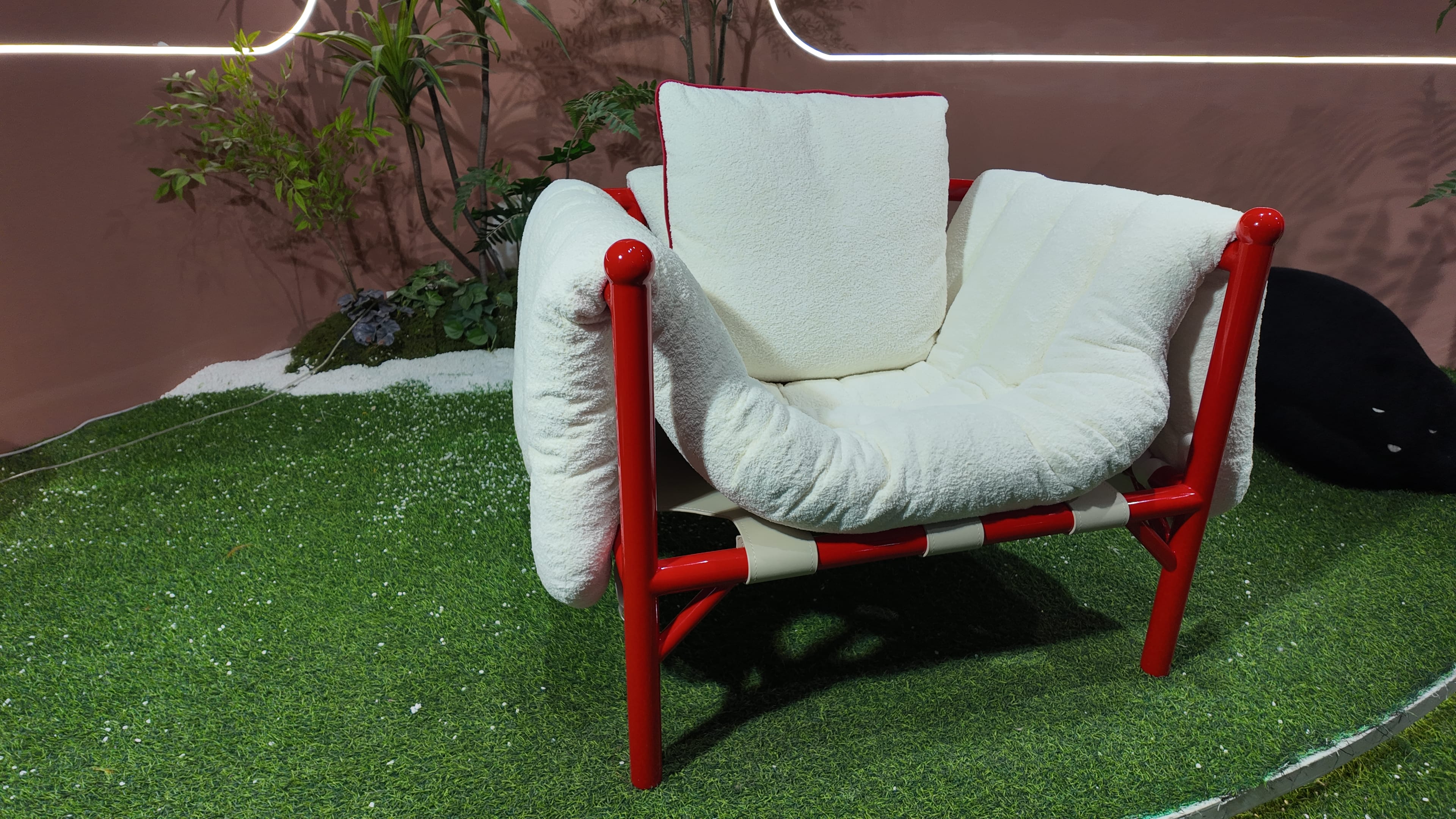 Fauteuil design en tissu bouclé et structure tubulaire laquée rouge – Détente