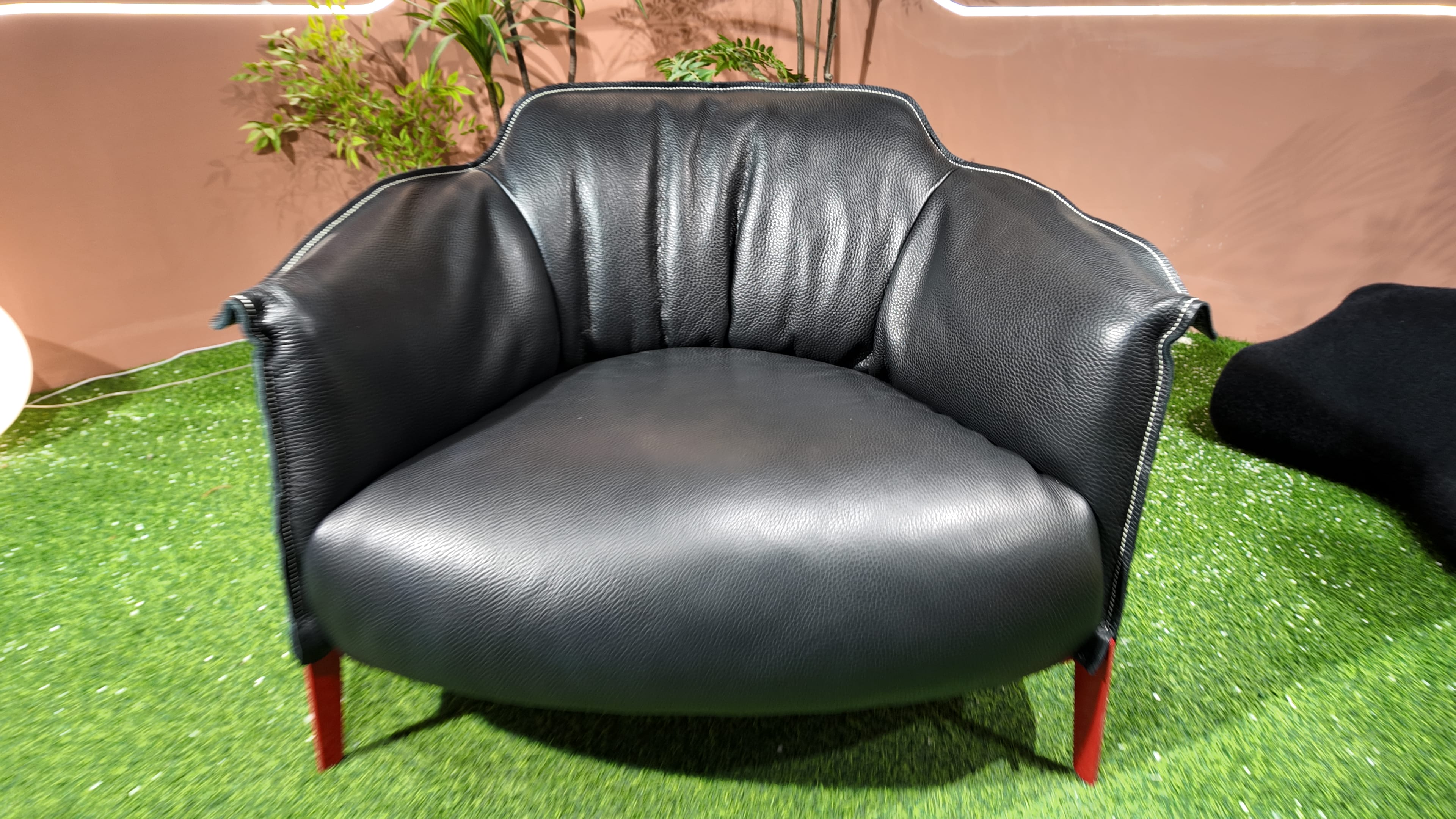 Fauteuil ARCHIBALD en cuir grainé noir à piètement acier laqué rouge