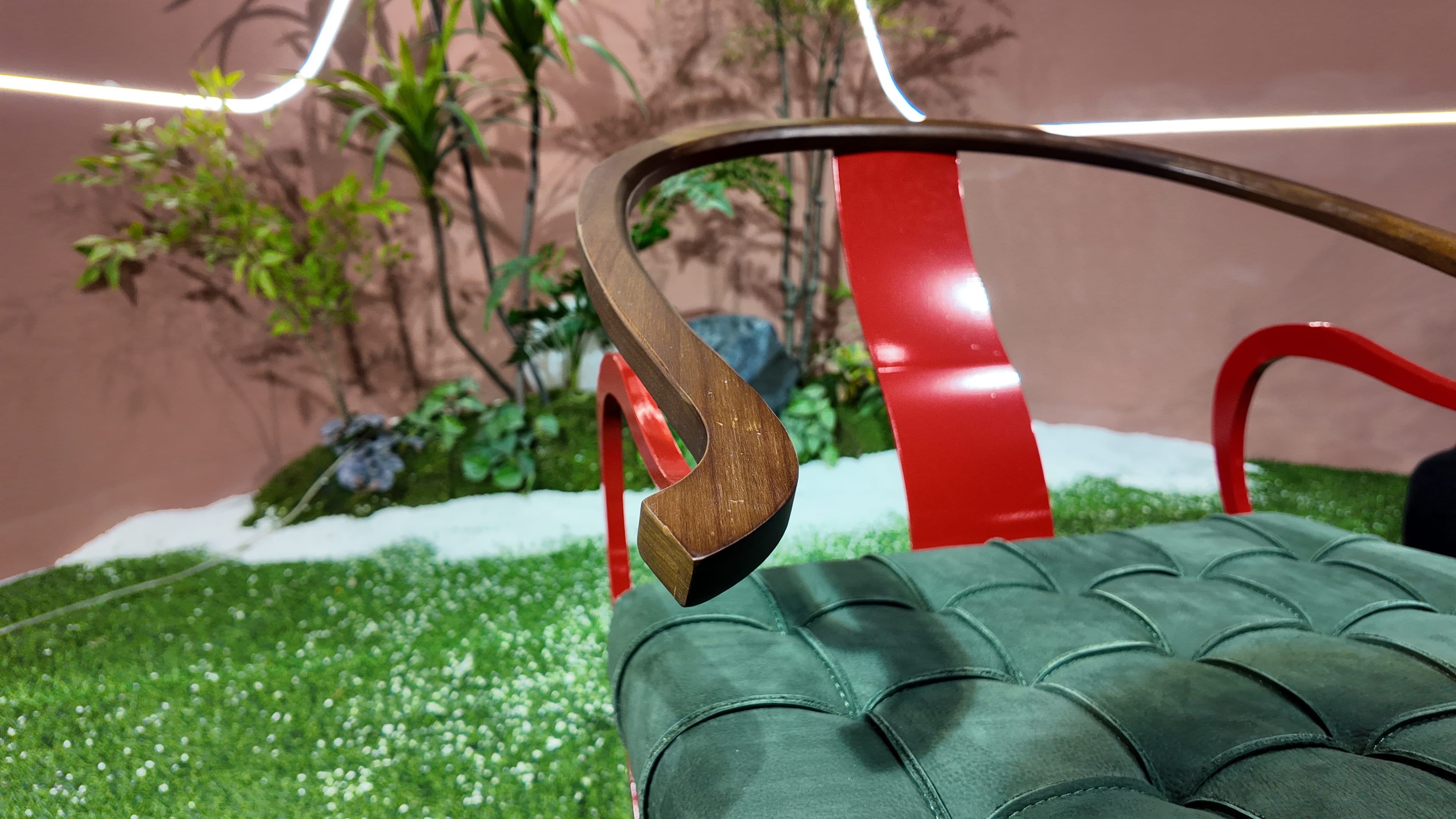 Fauteuil P40 – piètement croisé en métal laqué rouge et assise capitonnée en cuir vert